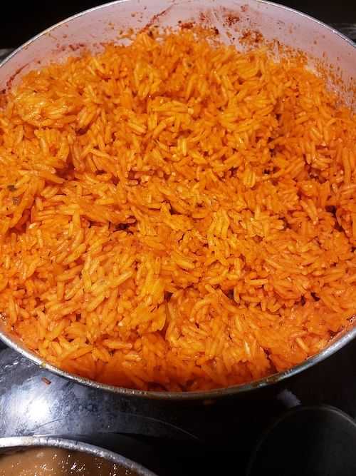 A pot of cooked, orange-colored seasoned rice.