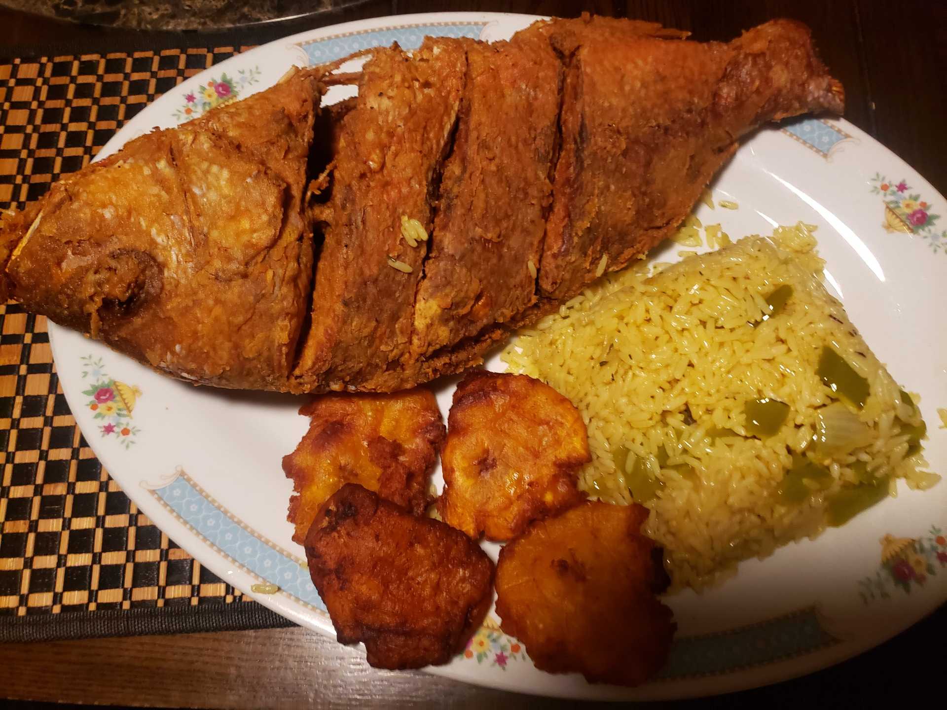 Plate of fried fish with rice and plantains.